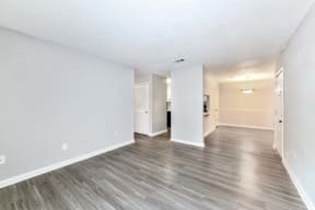 a bedroom with hardwood floors and white walls