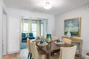 A dining room with a wooden table and chairs.