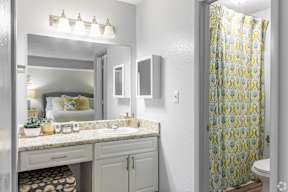 A bathroom with a mirror, sink, and shower curtain.