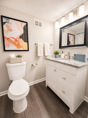A white toilet sits next to a white sink in a bathroom.