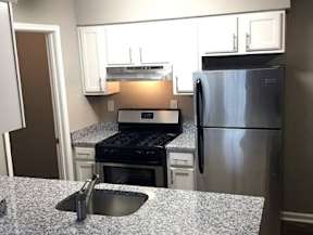 A kitchen with a stove, oven, and refrigerator.