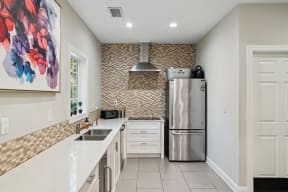 a modern kitchen with stainless steel appliances and white counter tops