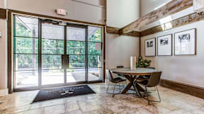A black mat with the number 9 on it is on the floor in front of a glass door.