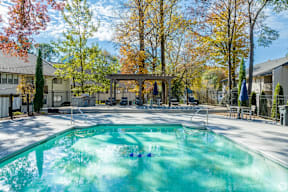 A swimming pool surrounded by a fence and trees.