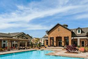 A large house with a pool in front.