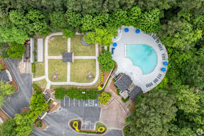 A bird's eye view of a park with a swimming pool and a playground.