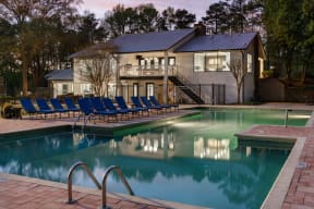 Veridian at Sandy Springs apartments pool with blue chairs and a house in the background