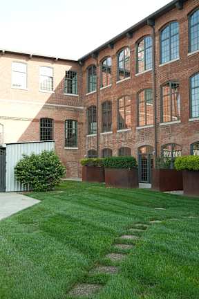 a yard in front of a brick building