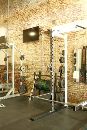 a gym with weights and a television in it
