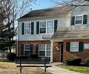 A house with green shutters and a brick facade.