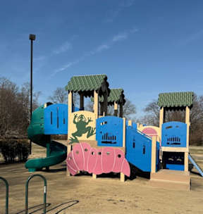 A colorful playground with a slide, swings, and a climbing structure.