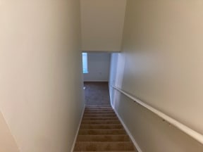 a view from the top of the stairs looking down into the living room