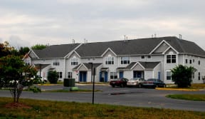 a row of houses with cars parked in front of them