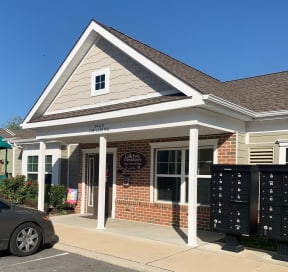 a building with mailboxes and a car parked in front of it