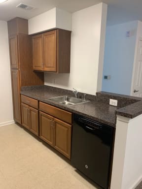 a kitchen with granite countertops and a black dishwasher