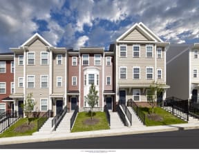 a rendering of a row of townhomes with a blue sky in the background