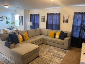 a couch with yellow pillows in a living room