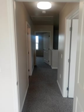 a hallway with a carpeted floor and white walls