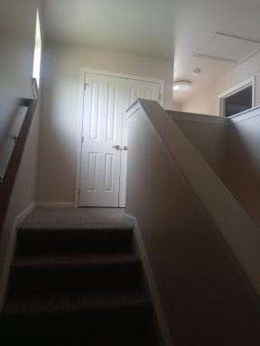 a staircase with a white door at the top of it
