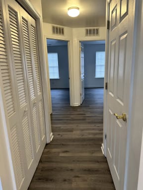 a hallway with white doors and a wooden floor