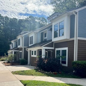 a row of houses with a sidewalk in front of them