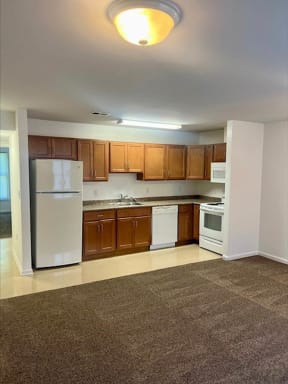 a kitchen with a white refrigerator freezer next to a stove top oven