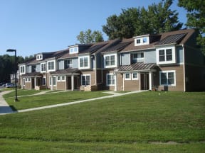 a row of houses on a grassy hill