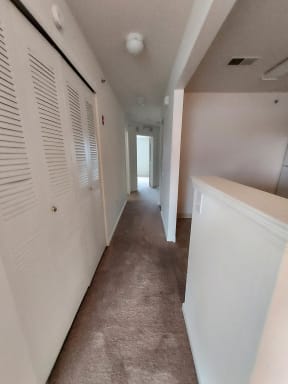 a hallway with white doors and a carpeted floor