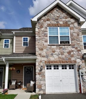 a house with a stone facade and a white garage door