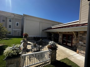 a patio with a table and chairs in front of a building