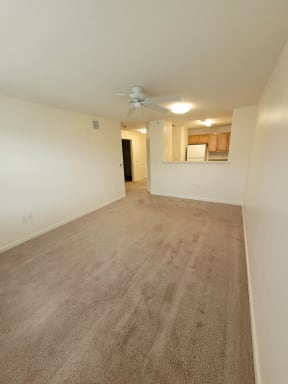 a bedroom with white walls and a ceiling fan