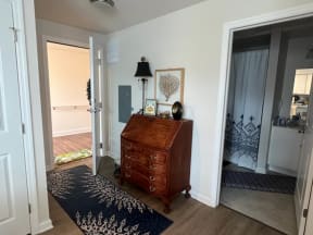 a room with a dresser and a lamp