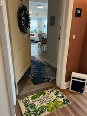 a hallway with a rug on the floor and a door open