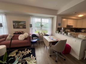 a living room with a kitchen in the background and a couch and table in the foreground