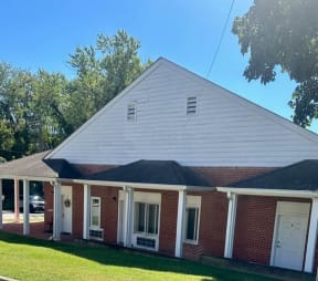 a brick house with white siding and a black roof