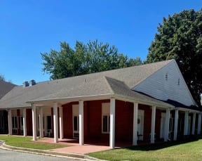 a red brick building with white pillars and a gray roof