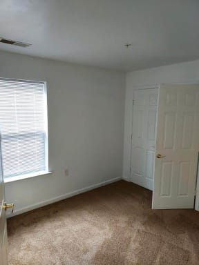 an empty room with a window and a door