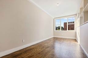 Empty room with wooden floors and a window.