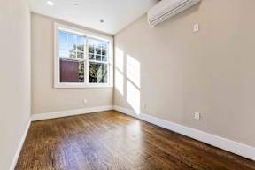 A room with a window and wooden floors.