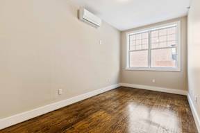 A room with a window and wooden floor.