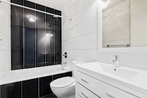 A white bathroom with a toilet, sink, and bathtub.