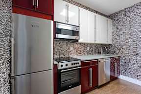 A kitchen with a stainless steel refrigerator, oven, and microwave.