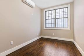 A room with a window and wooden floor.