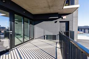 A modern building with a glass door and a black railing.