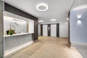 A hallway with a marble counter and tiled floor.