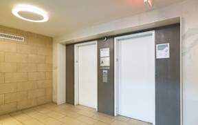 A hallway with two doors, one of which is closed and has a sign on it.