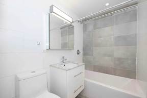 A white bathroom with a toilet, sink, and bathtub.