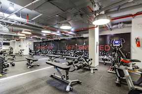 A gym with a variety of equipment including treadmills, stationary bikes, and weight machines.