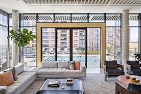 a room with couches and chairs and a view of a building at The Lively, Jersey City New Jersey