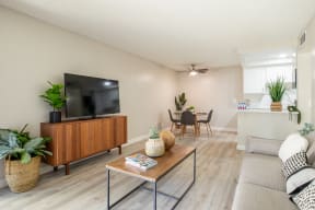 Living room with a TV and dining room in the background at Banbury Apartments Riverside